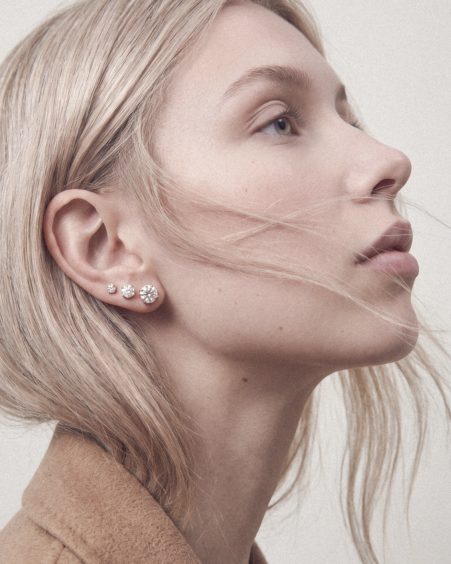 Profile of a woman wearing diamond stud earrings